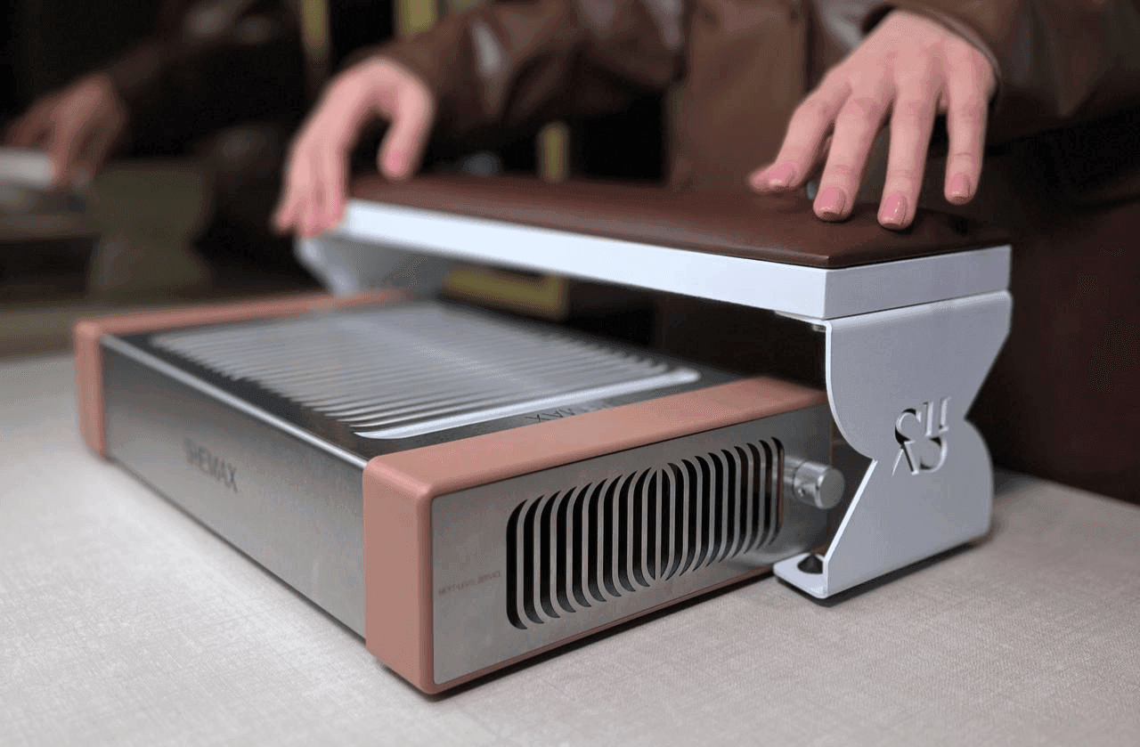 Hands hover over a sleek, modern indoor grill with a brown top and silver base.